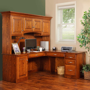 Oak L corner desk with a raised panel hutch, keyboard shelf and three drawer pedestal in a green walled office