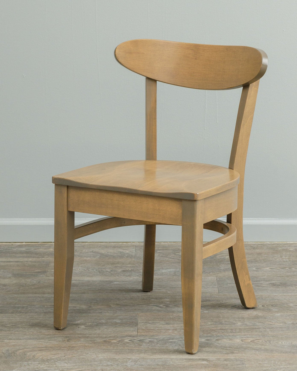 Mid century modern dining chair in a light driftwood stained maple with oval back rest and shaped wood seat