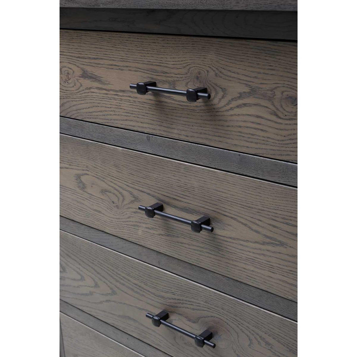 Detail of the gray dresser's drawer fronts with pronounced oak grain and matte black bar pulls