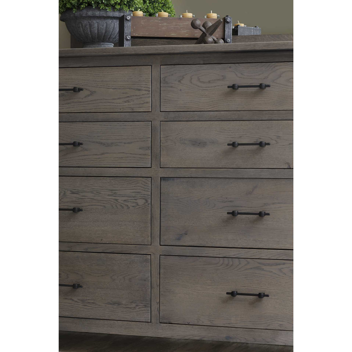 Detail of the eight-drawer solid oak dresser front showing cathedral wood grain and hand-forged black iron pulls