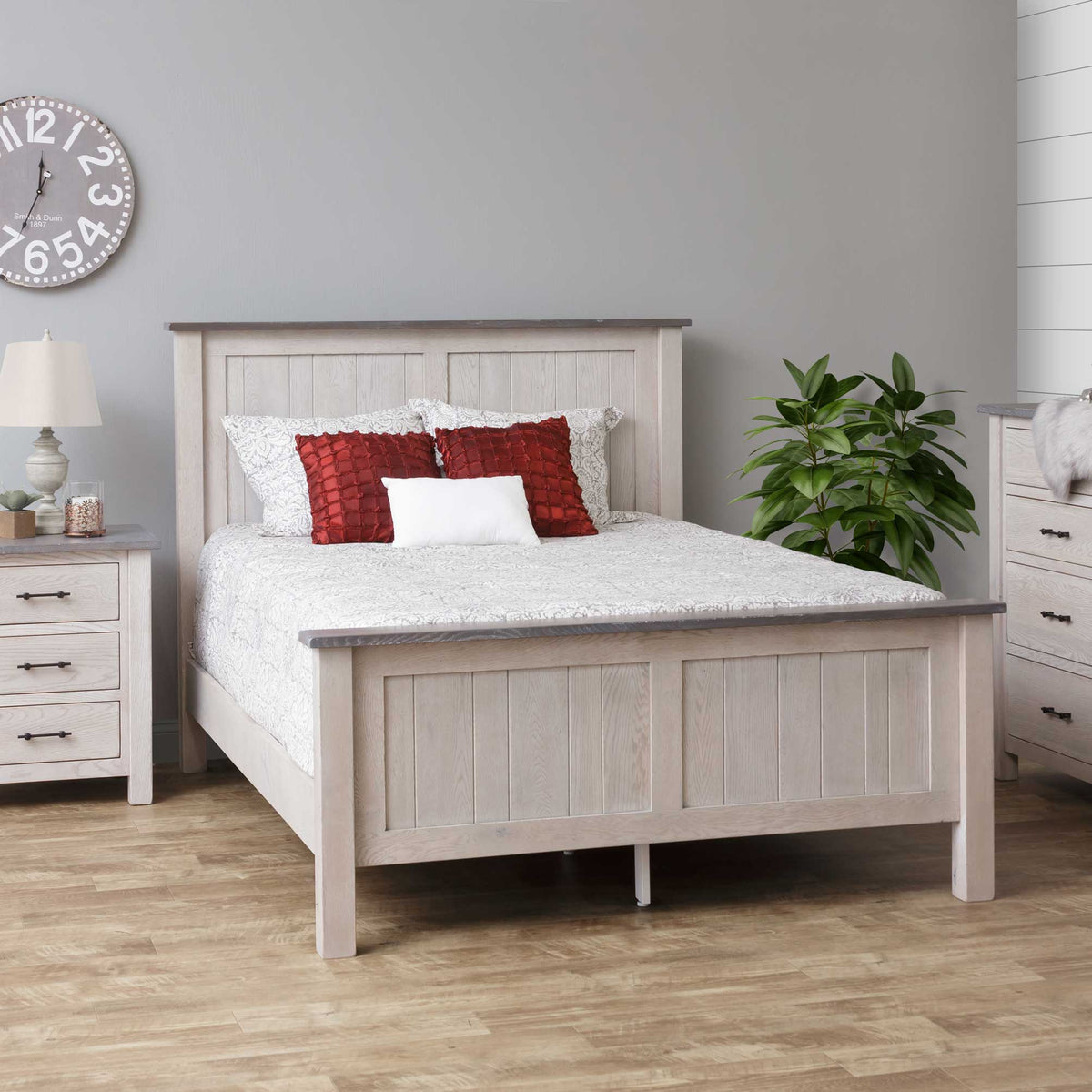 Whitewashed oak panel bed with gray top caps and red accent pillows beside a matching nightstand and chest