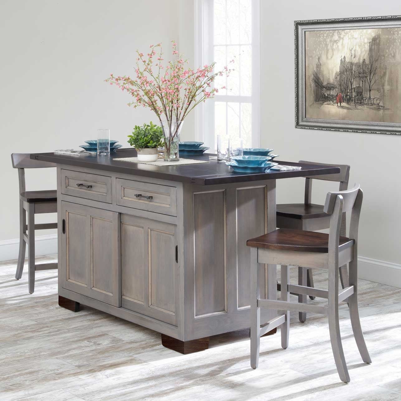 Gray painted kitchen island with dark plank drop leaf top, two drawers, sliding doors and three stools