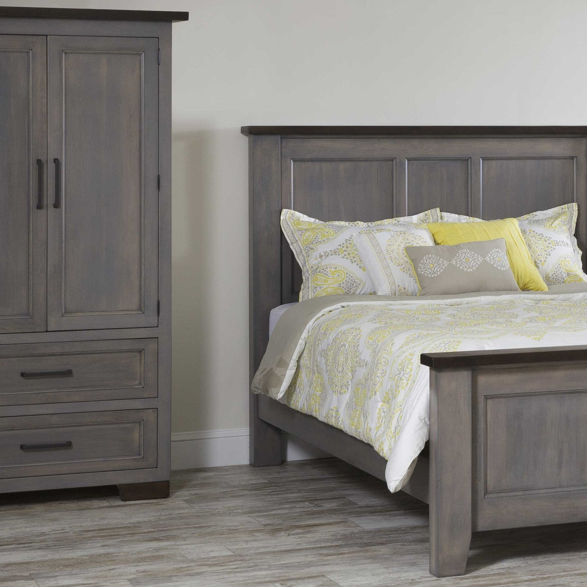 Gray armoire beside a matching panel bed with yellow and gray patterned bedding in a bedroom