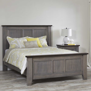 Gray solid wood queen panel bed with a dark stained top rail, styled with yellow paisley bedding beside a matching two-tone nightstand