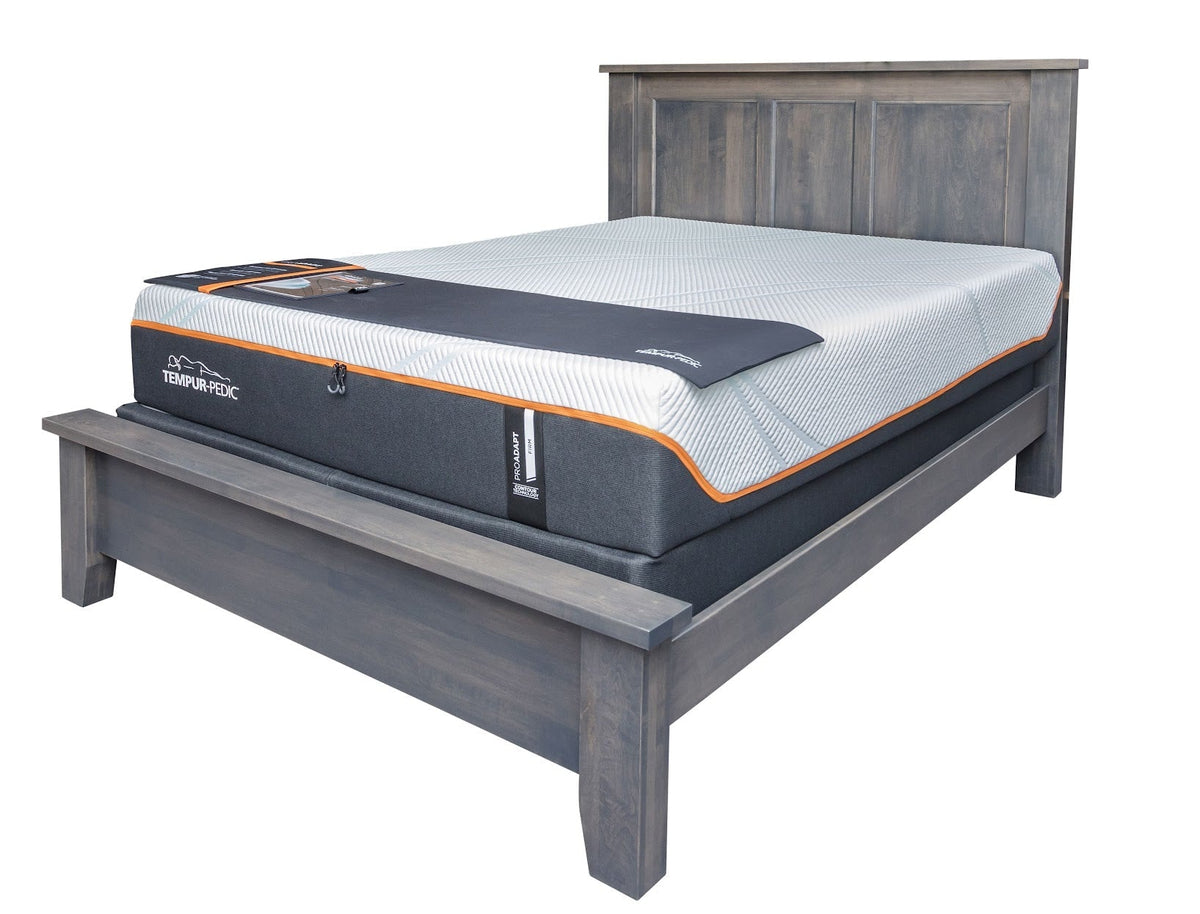 Solid wood panel bed frame in a gray stain shown supporting a Tempur-Pedic mattress and foundation without a footboard panel