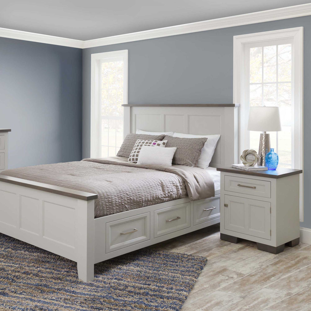 Bright bedroom scene with a white and gray solid wood storage bed with side drawers and matching one-drawer nightstand