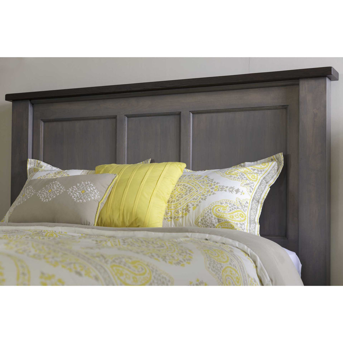 Close-up of the three-panel solid wood headboard in a charcoal gray finish with a darker overhanging top cap