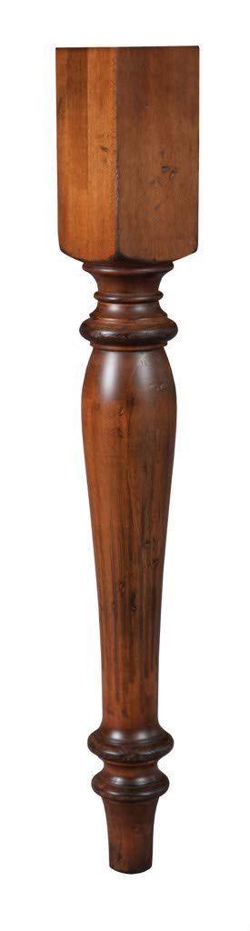 Detail of the hand-turned solid wood dining table leg in a warm brown stain with tapered vase silhouette
