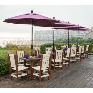 Long brown and ivory poly dining set with slat back chairs under burgundy umbrellas at a waterfront deck