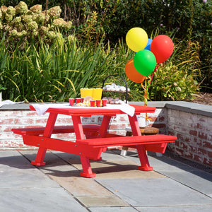 Red poly children's picnic table with A frame legs, party cups and balloons on a bluestone patio