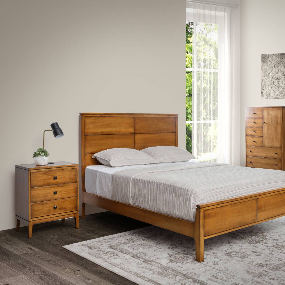 Maple panel bed with a nightstand, lamp and chest of drawers in a bright mid century bedroom