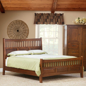 Mission slat bed in warm oak with a curved slat headboard and matching footboard in a beamed bedroom