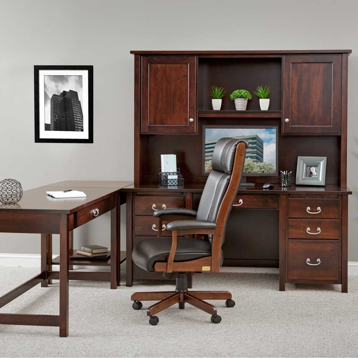 Dark cherry desk and hutch with leather executive chair and a matching writing table forming an L in a home office