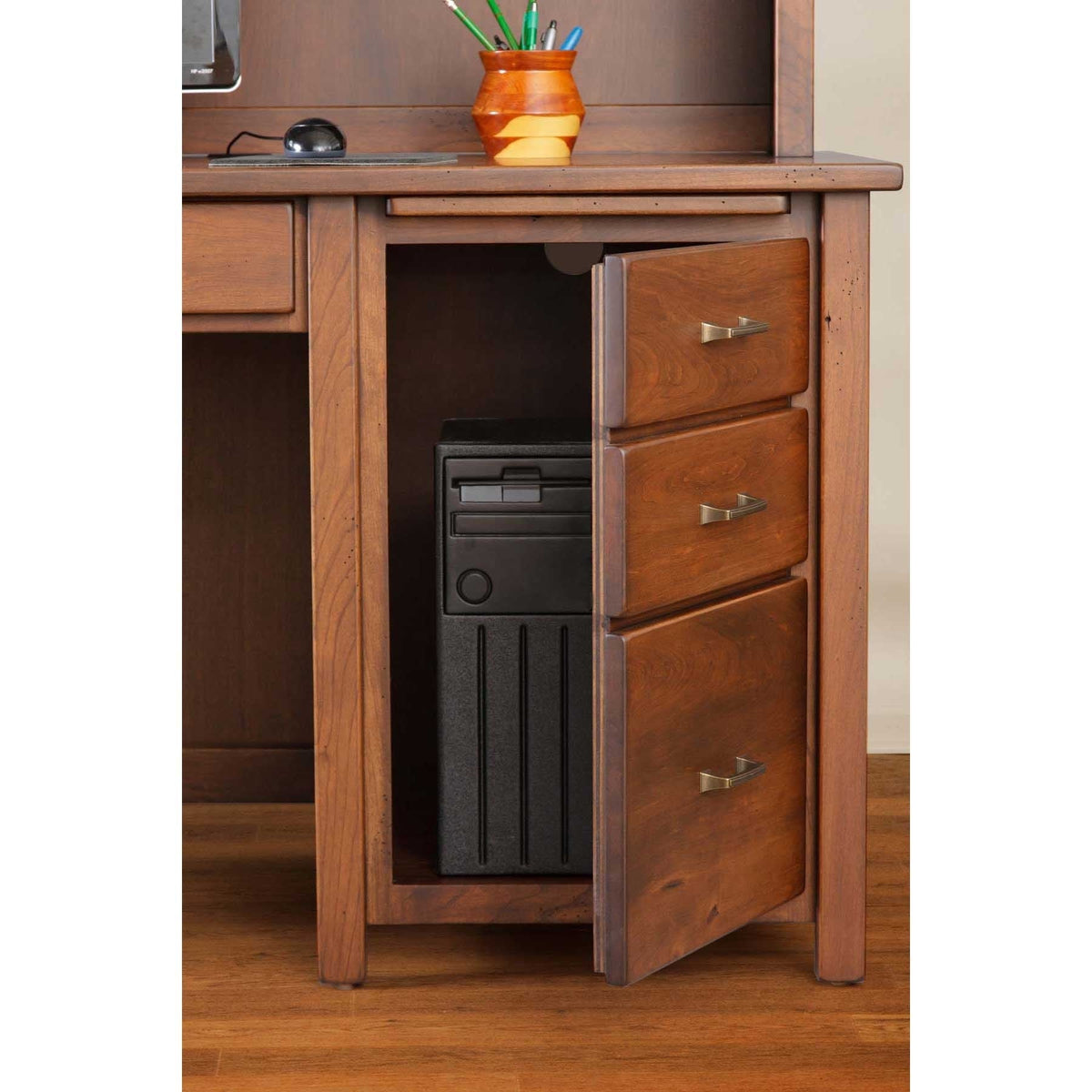 Home office scene with a cherry hutch desk, letter organizer and floor lamp against a warm brown wall
