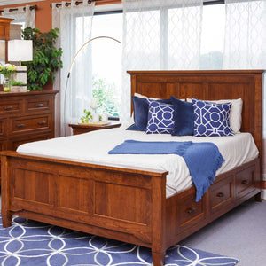 Cherry platform captain storage bed with three footboard drawers, tall panel headboard and blue accent bedding