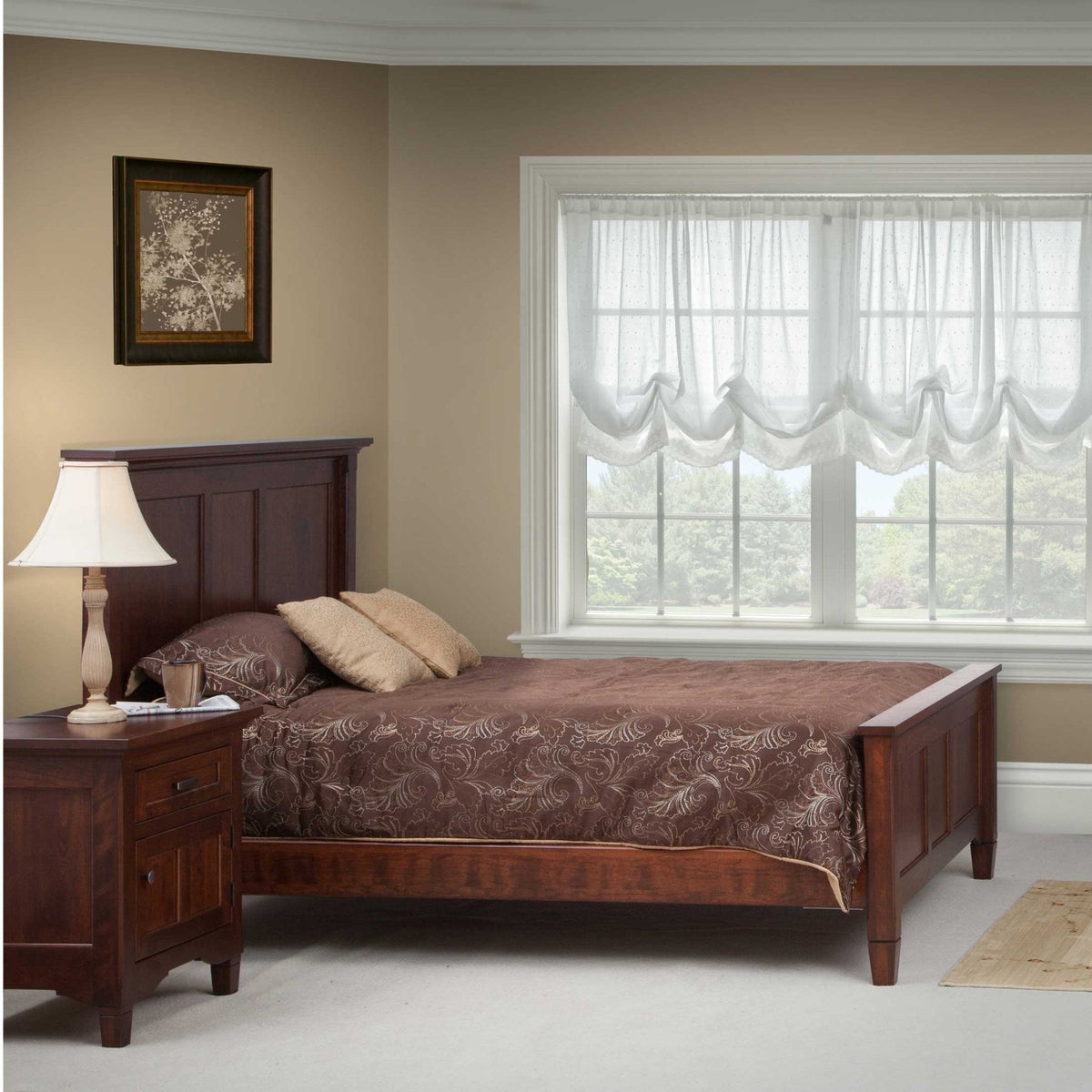Dark cherry panel bed with nightstand and lamp in a bedroom with brown paisley bedding and sheer curtains