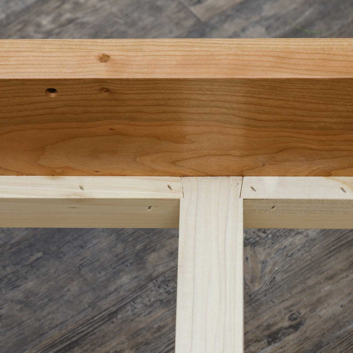 Close-up of the canopy bed's cherry side rail joined to unfinished maple center support slats
