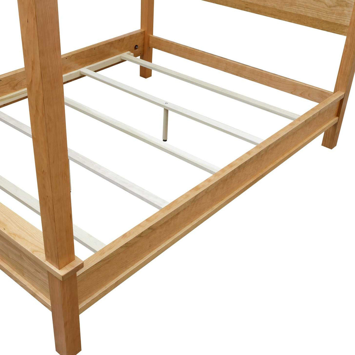 Foot corner of the cherry canopy bed frame showing the wood rails, painted slats and adjustable center support leg