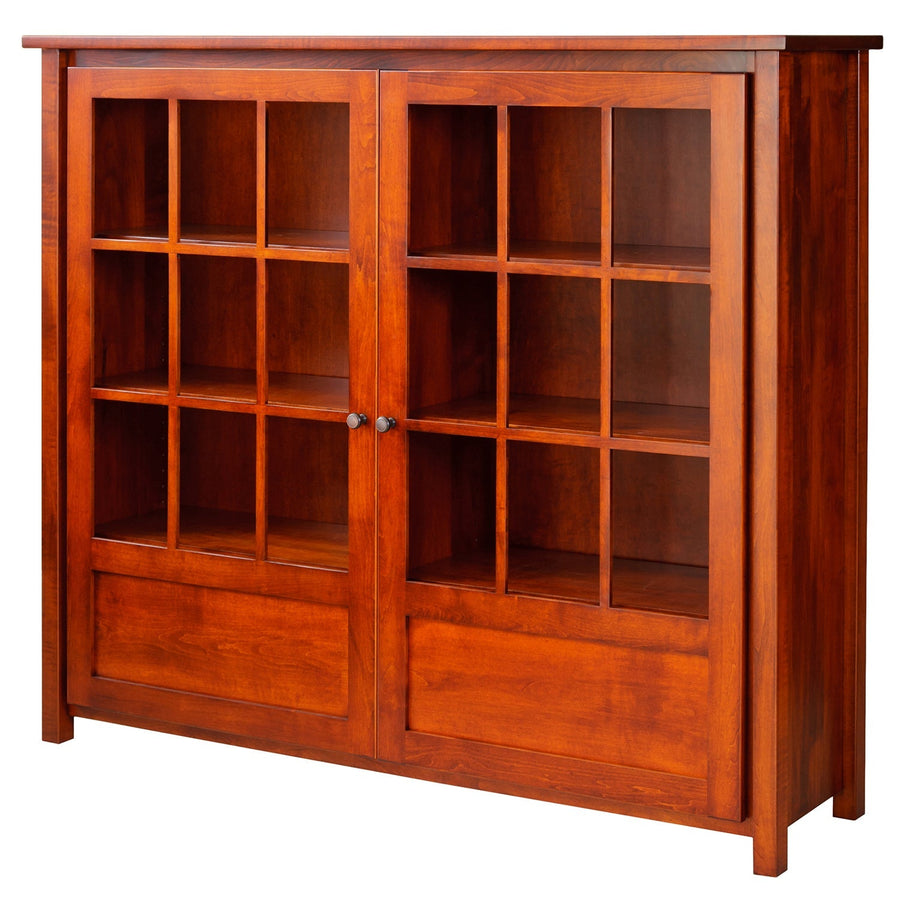 Large cherry bookcase with two nine-pane glass doors, three interior shelves and solid raised panels below on a white background