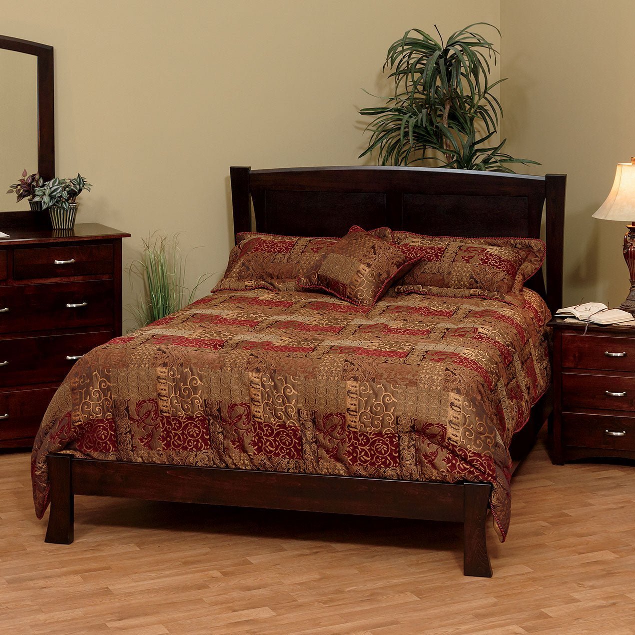 Modern arched panel bed in warm cherry with curved posts and low footboard beside a mirrored dresser