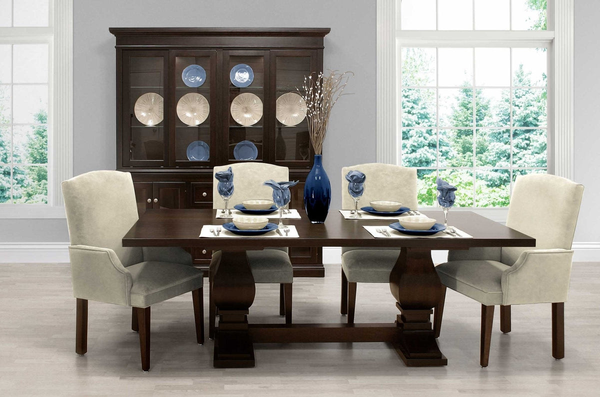 Dining room with a dark espresso double pedestal table, cream upholstered chairs and a lighted china cabinet