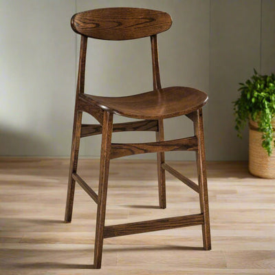 Mid century modern counter stool in dark oak with an oval floating back, saddle seat and angled legs