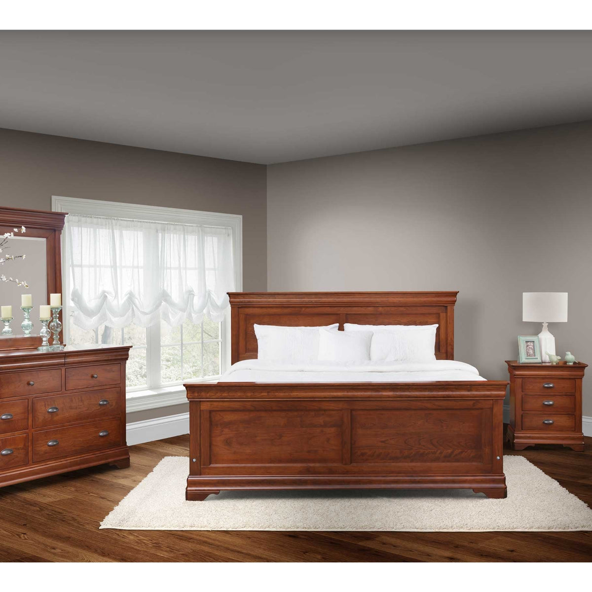 Cherry panel bed with white bedding between a dresser with mirror and a nightstand on wood flooring