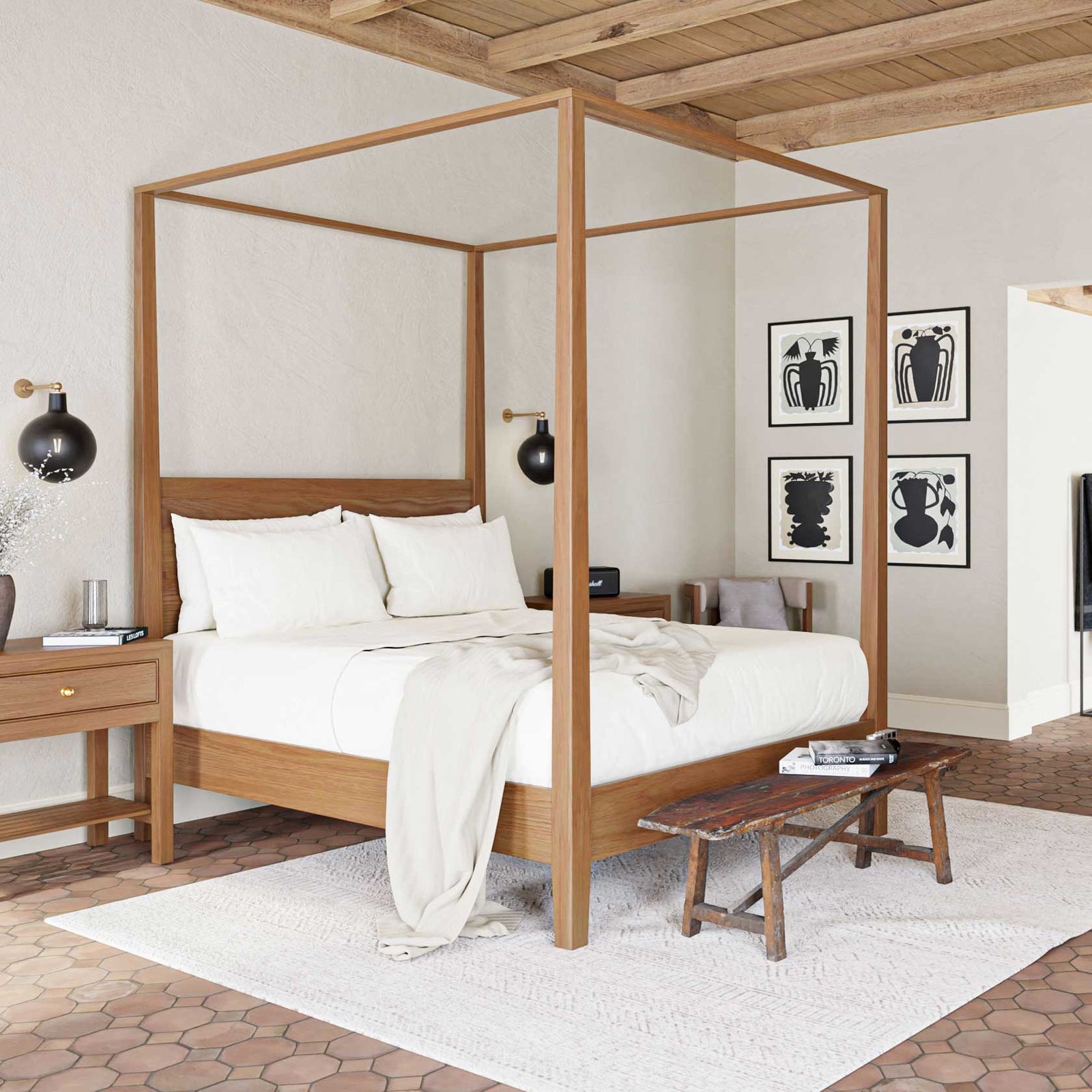 Light oak canopy bed with tall square posts and a slim frame, dressed in white linens under a beamed wood ceiling