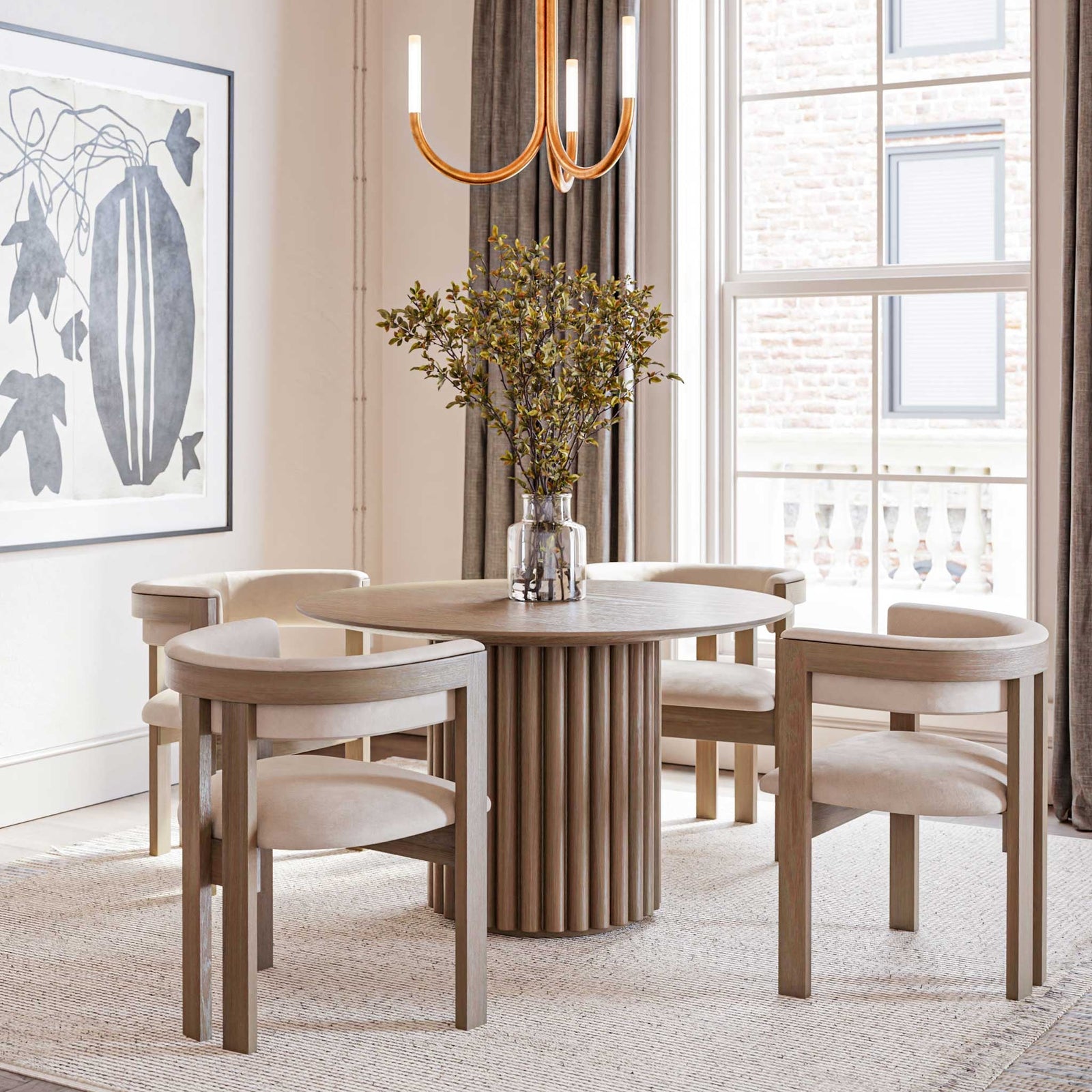 Round pedestal dining table with a fluted column base and curved cream upholstered chairs in a bright dining room