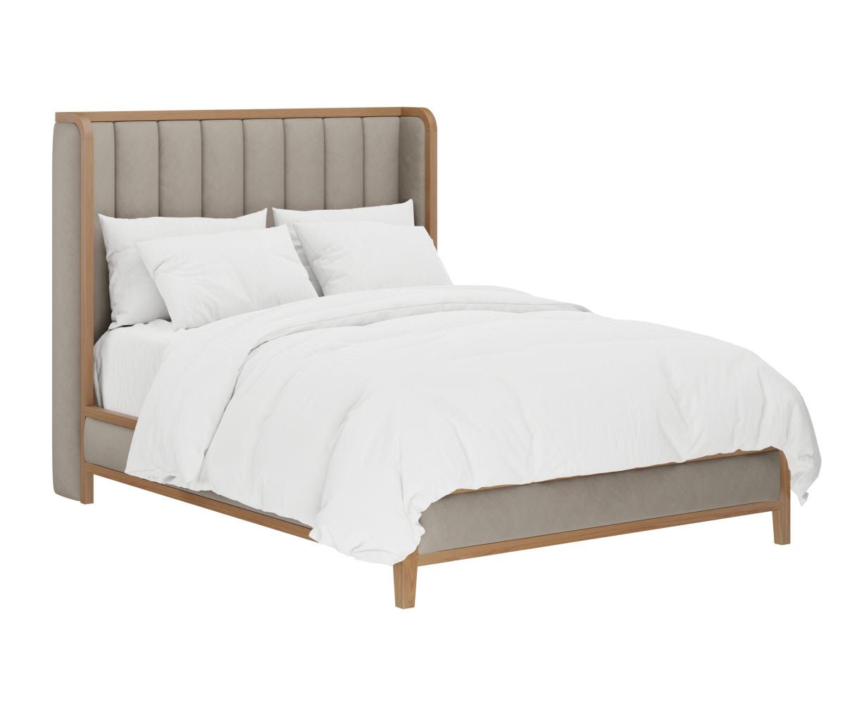 Upholstered bed with a tall channel tufted wingback headboard in cream fabric, styled in an ornate Paris style bedroom