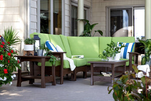Brown poly modular sectional with lime green cushions, striped pillows and matching tables on a shaded deck