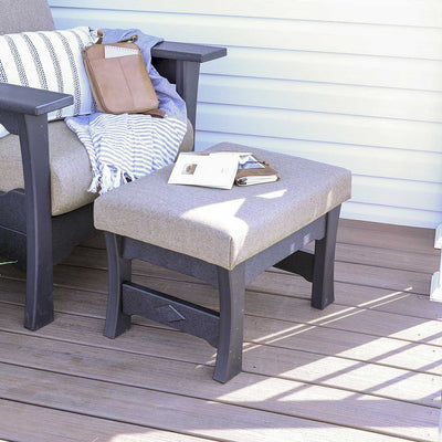 Black poly patio ottoman with a thick gray cushioned top and diamond stretcher beside a matching deep seat chair
