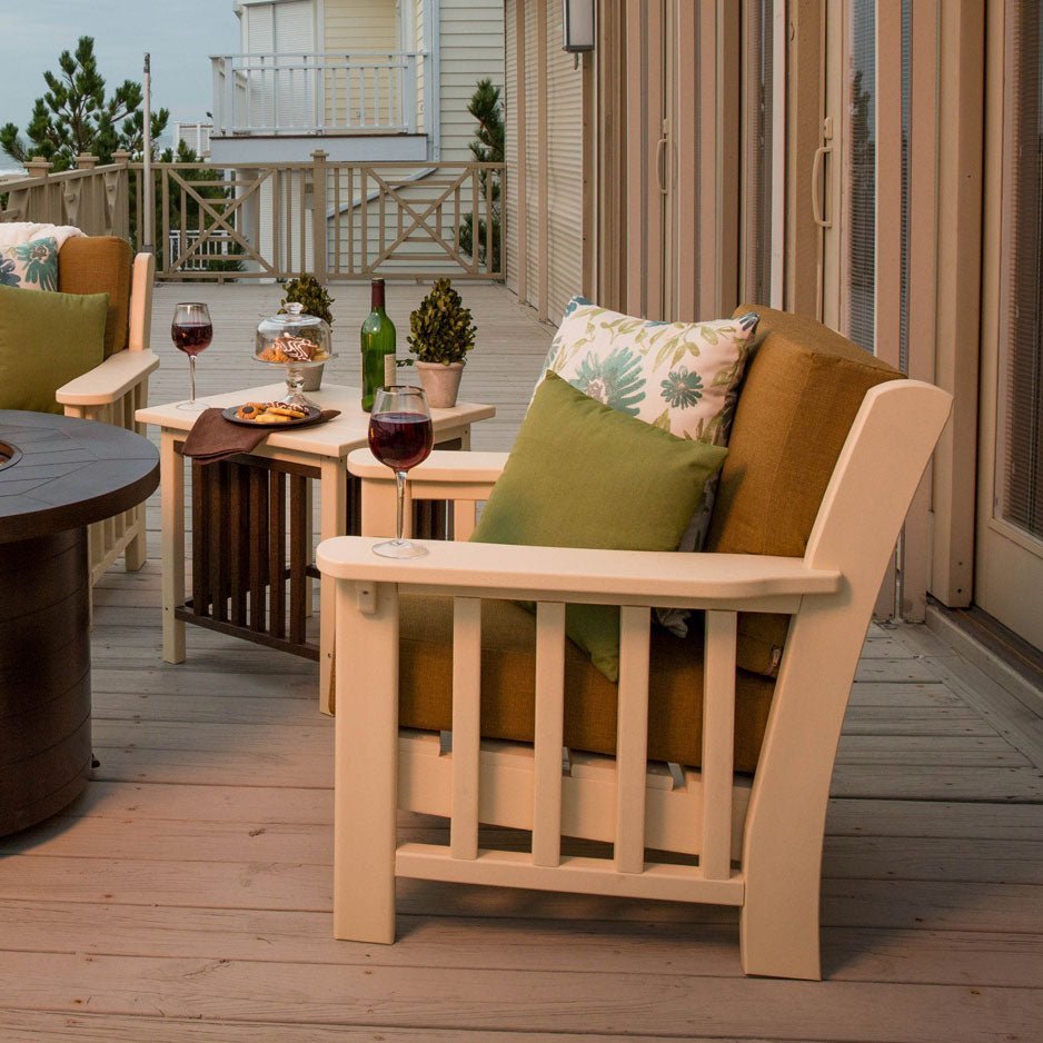Sand colored poly Mission patio chairs with green and gold cushions on a beach house deck at dusk