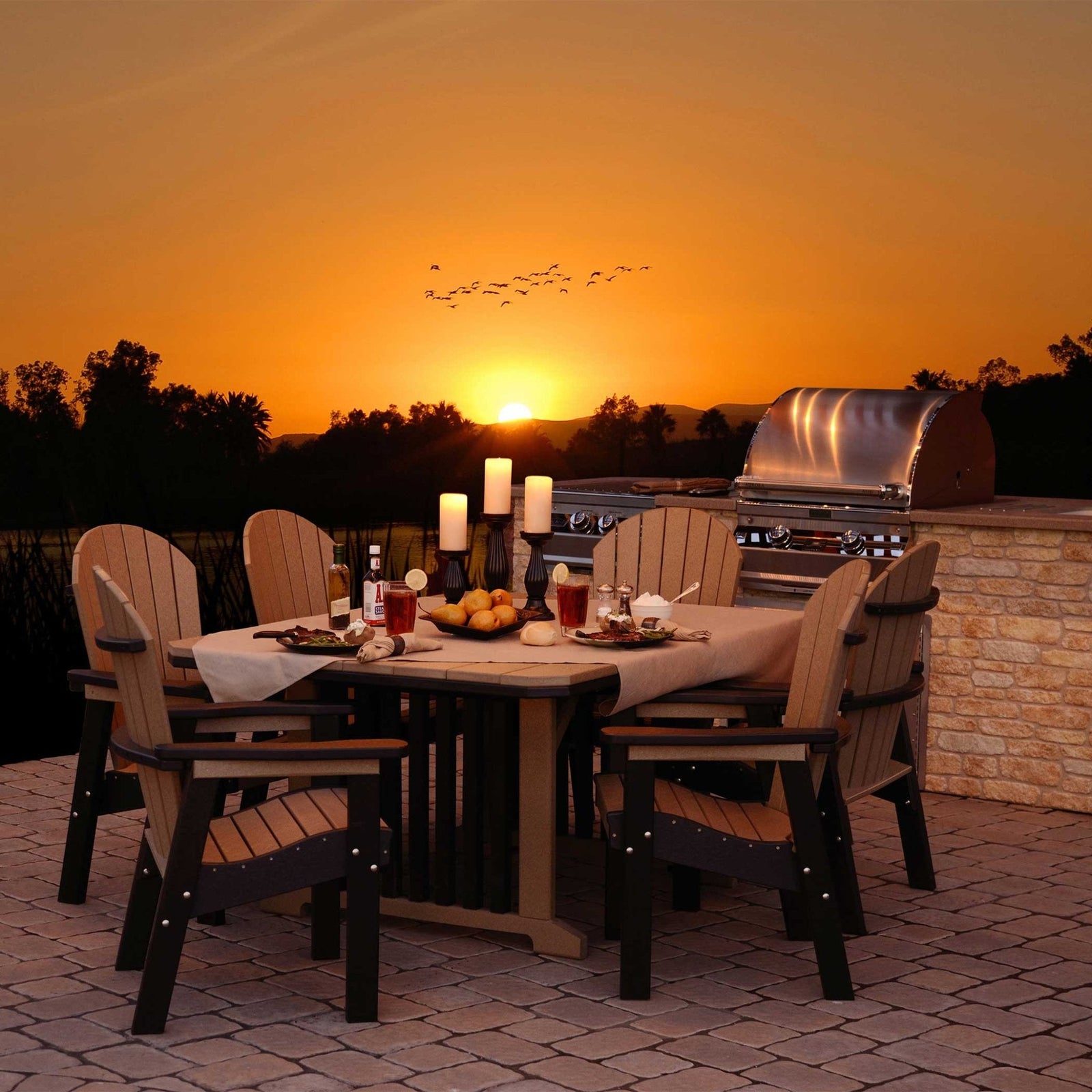 Weatherwood and black poly patio dining set for six beside an outdoor grill at sunset
