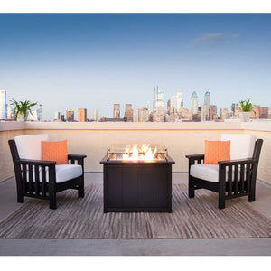 Black poly Mission cushion chairs and a rectangular gas fire table on a rooftop terrace at dusk