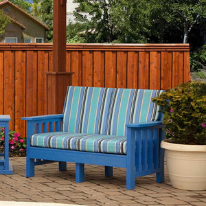 Blue poly Mission cushion loveseat with wide striped seat and back cushions on a paver patio