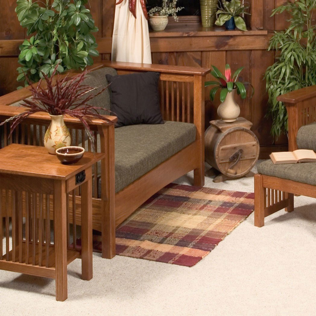 Oak Mission club loveseat with olive cushions, spindle sides and black pillow in a knotty pine living room