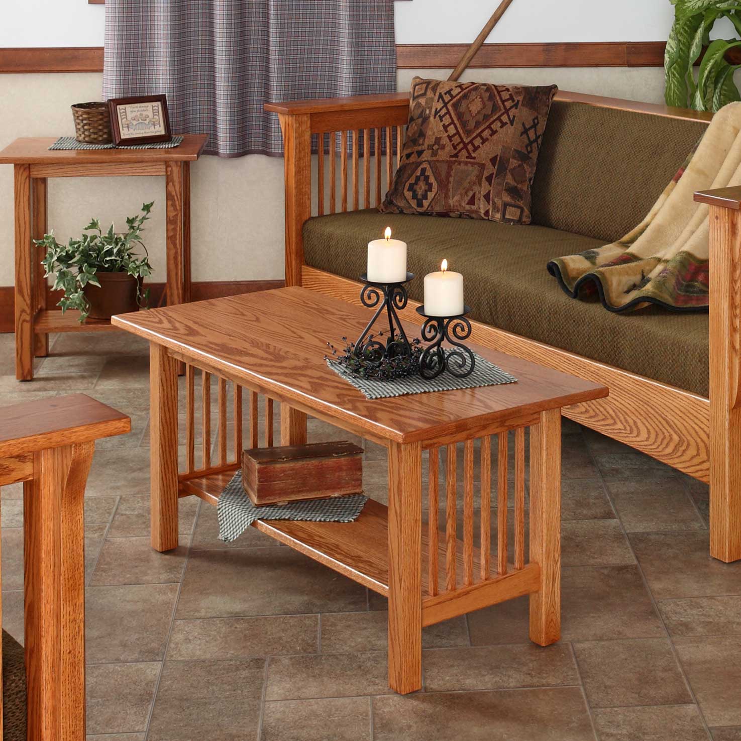 Oak junior Mission coffee table with slat sides and bottom shelf, candles on top and a green cushioned sofa behind