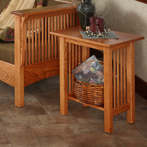 Oak Mission junior end table with slat sides and a bottom shelf holding a basket of magazines