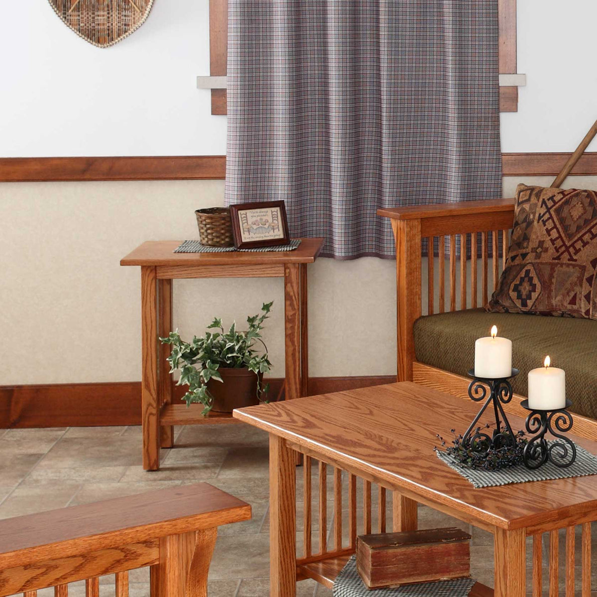 Oak Mission junior end table with slat sides and lower shelf holding a framed piece and ivy beside a green loveseat