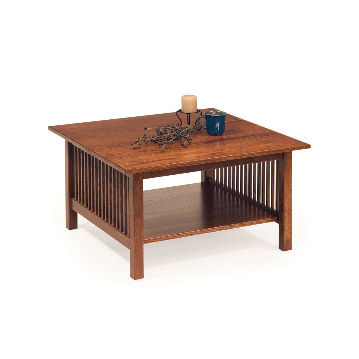 Square oak Mission coffee table with slat sides and a lower shelf, candle and blue mug on the top