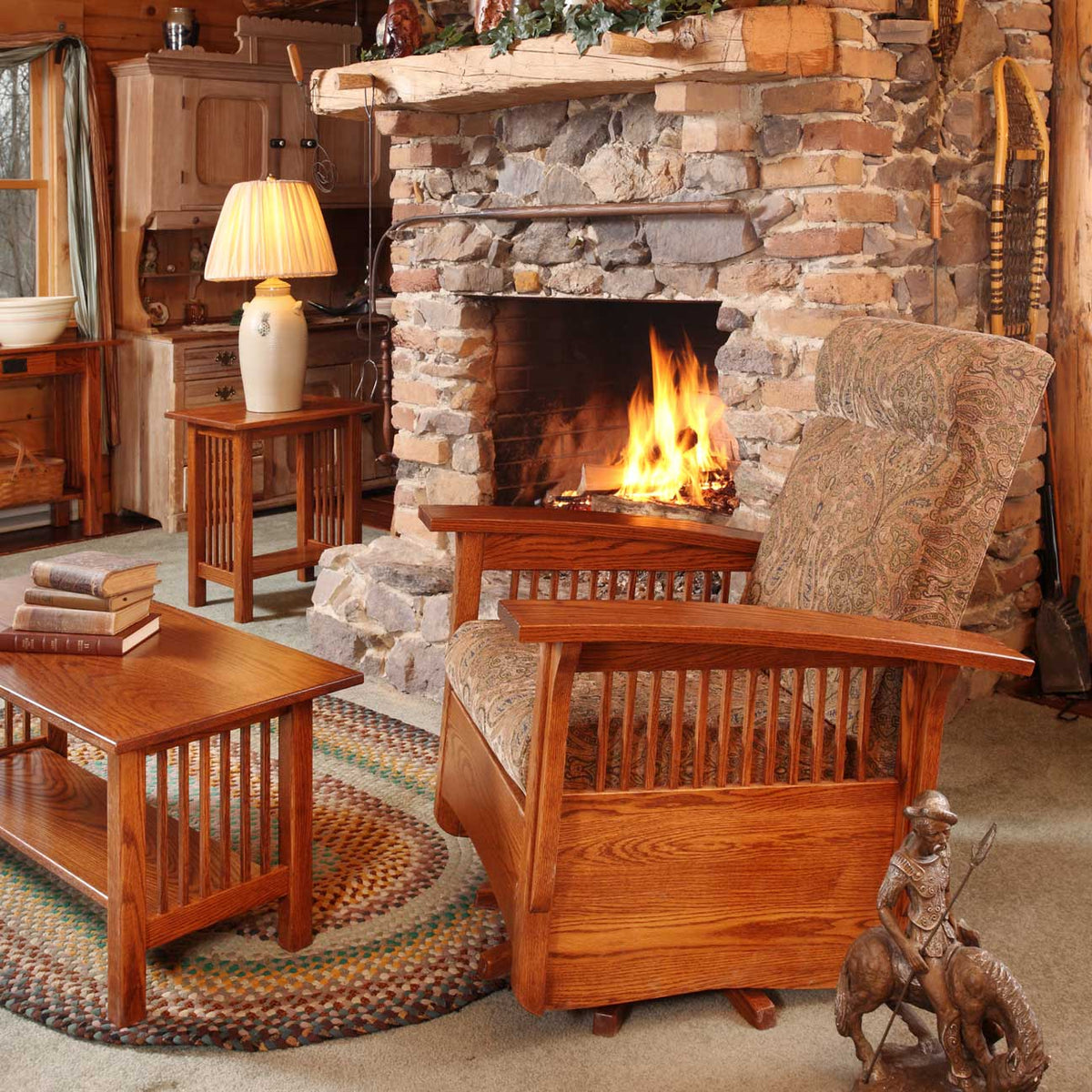 Oak Mission swivel glider with paisley cushions in a log cabin room by a stone fireplace with a braided rug