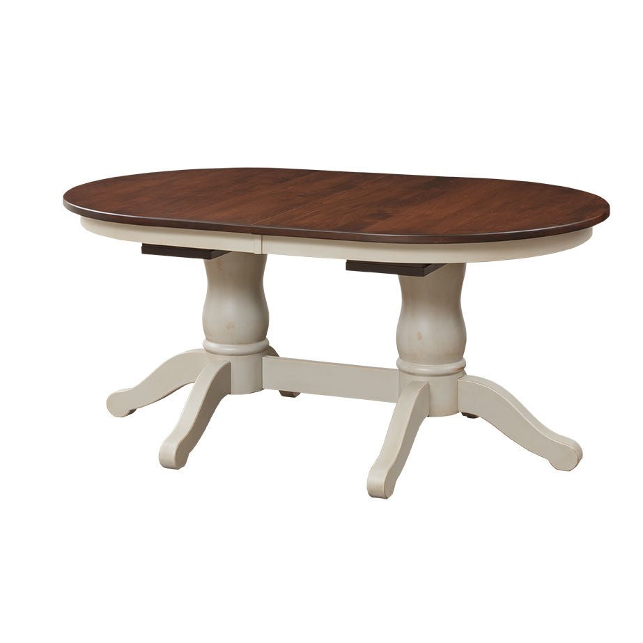 Two-tone oval dining table with dark stained top, cream turned pedestals and scrolled feet on white