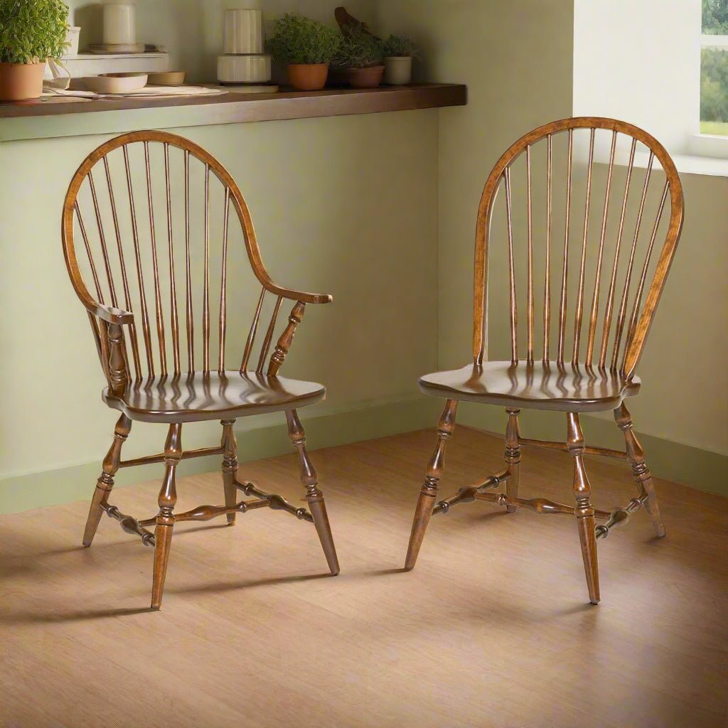 Pair of Windsor chairs with bow-back spindles, one with arms, turned legs and shaped saddle seats