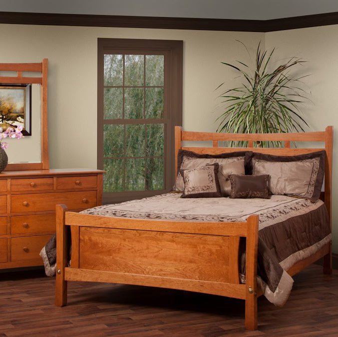 Cherry panel bed with arched slat headboard and paneled footboard, styled with brown bedding beside a mirrored dresser