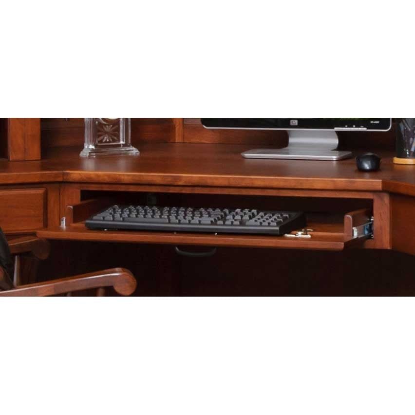 Keyboard tray slid out under the cherry corner desk with a black keyboard, monitor and mouse above