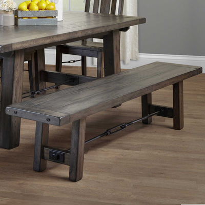 Weathered gray dining bench with a thick plank seat, angled legs and a black iron turnbuckle stretcher