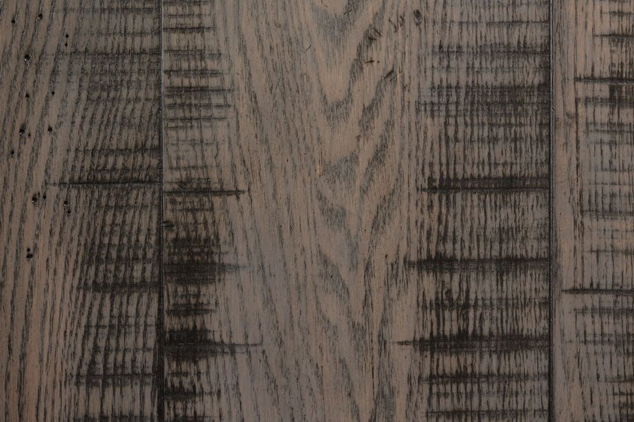 Close-up of weathered gray oak planks with dark distress marks and open grain texture