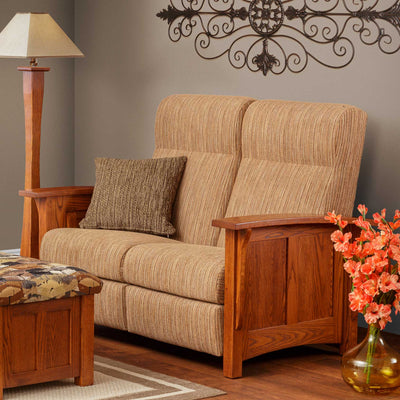 Oak paneled Mission reclining loveseat in tan striped chenille with a matching pillow and a floor lamp behind