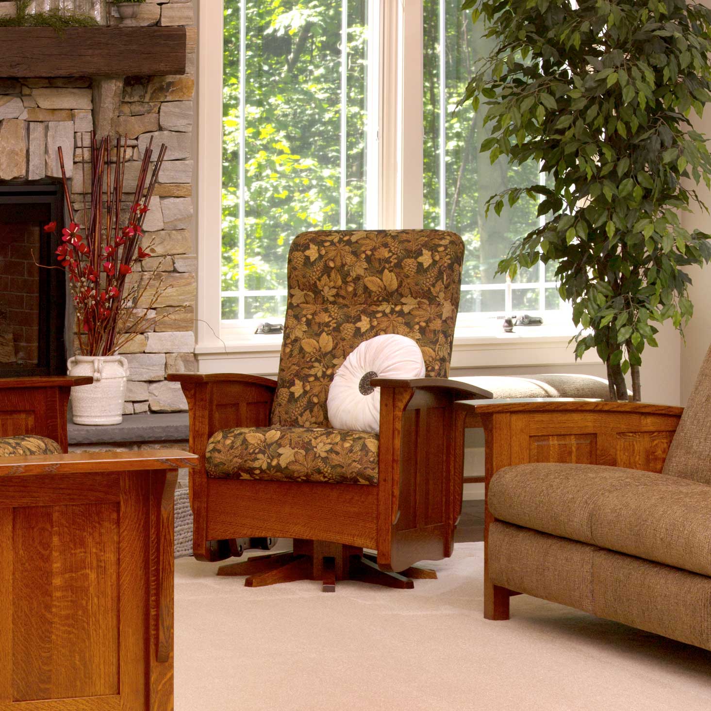 Quartersawn oak swivel glider with autumn leaf tapestry cushions and white bolster in a room with a stone fireplace